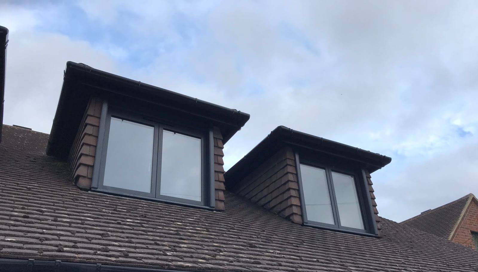Image of two aluminium windows illuminating the top floor of the house.