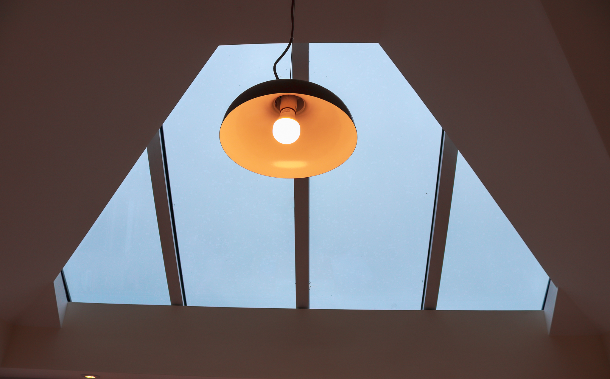 View of see through roof with warm hanging lamp.